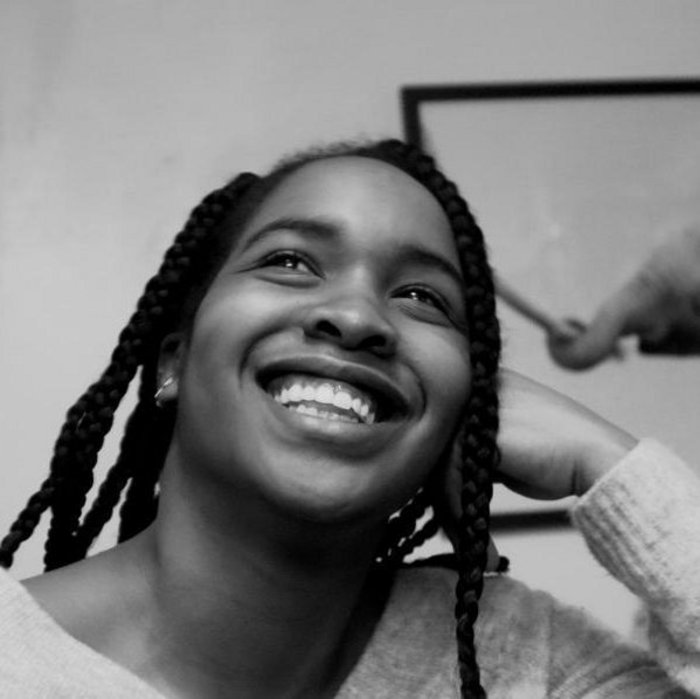 Black and white photograph of a smiling black woman with braids.