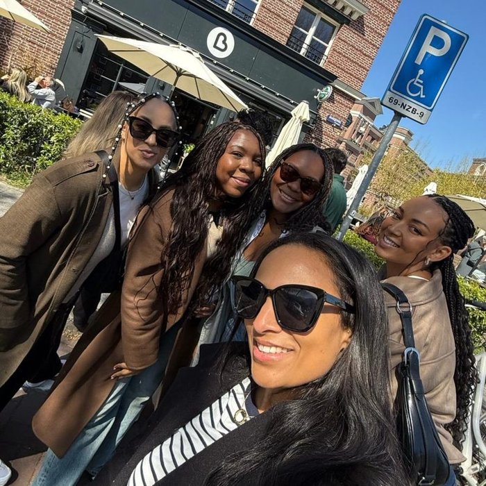 Group of black women pose for a selfie in a Dutch street.