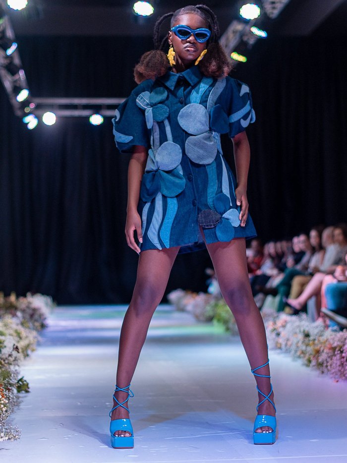Black model wearing mini dress made out of repurposed denim.