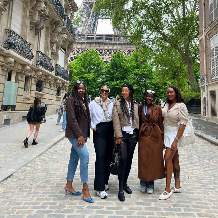 A group of black women posing for a photograph in front of the Eiffel Tower